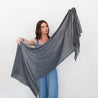 Model holding up 100% Cashmere naturally dyed Scarf by Tavy Tavy in charcoal dark grey